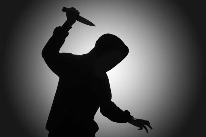 Mysterious,Man,Wearing,Black,Hoodie,Holding,A,Knife,To,Stab