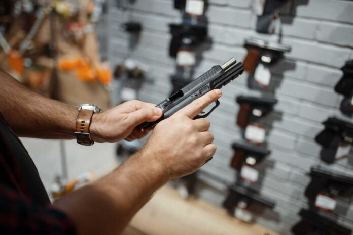 Man,Choosing,New,Handgun,In,Gun,Shop